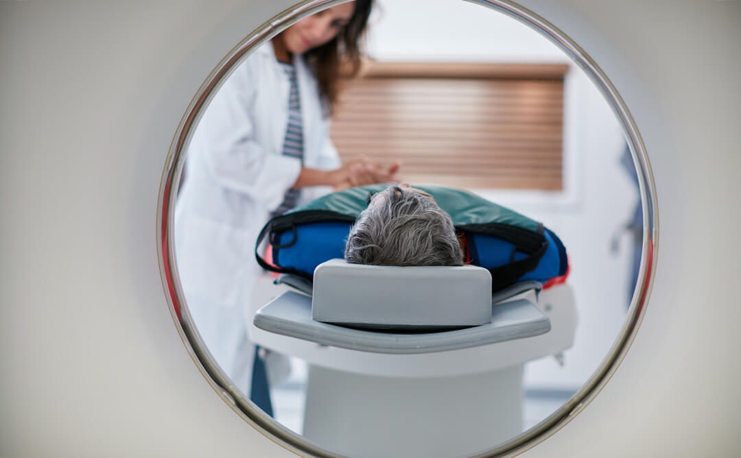 Doctor standing over patient on MRI table